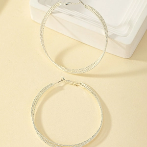 Detail of multi-layer twisted texture silver hoop earrings with triple-line design