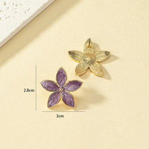 Detail view of purple enamel flower earrings with gold metal back and 2.8cm x 3cm dimensions