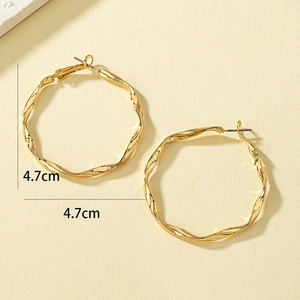 Détail de créoles torsadées dorées de 4,7 cm avec une finition miroir métallique