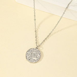 Silver sun coin pendant necklace with celestial relief on a classic cable chain
