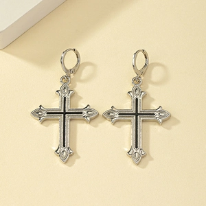 Vue macro des boucles d'oreilles croix vintage avec émail noir et fermoir anneau