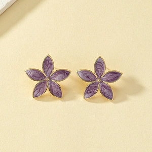 Elegant purple enamel flower stud earrings with golden edges shown on a beige paper