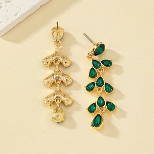 Detail of green teardrop gemstone earrings with gold leaf design and pin closure