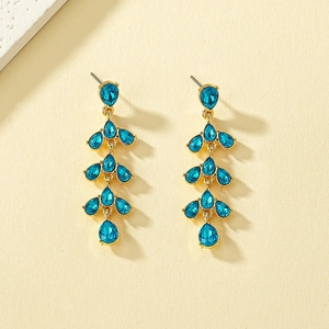 Elegant gold drop earrings with tiered blue water-drop crystals on a textured background