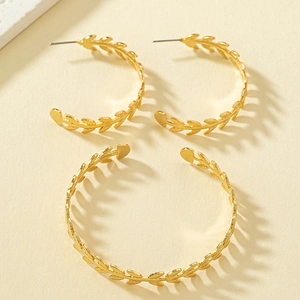 Elegant gold laurel leaf jewelry set featuring C-shaped earrings and matching cuff bracelet