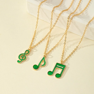Three-piece golden music note necklace set with green enamel treble clef and music notes