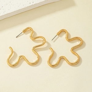 Minimalist gold floral earrings with abstract wavy lines on textured stone background