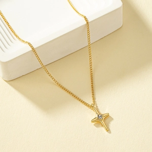 Elegant gold-plated dainty cross chain necklace with a sparkling starburst pendant