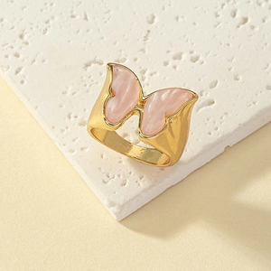 Eleganter goldener Schmetterling Ring mit rosa Emaille auf texturiertem Stein
