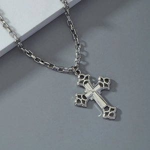 Collier avec pendentif croix argentée évidée et strass brillant au centre