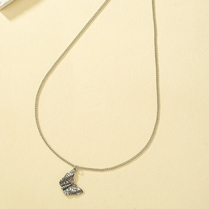 Vintage silver butterfly pendant necklace with detailed engraved wings on a delicate chain