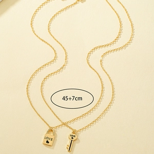 Detail view of gold enamel lock and key pendants with LOVE engraving and 45cm chain length
