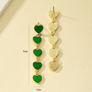 Detail view of 7cm long dangling earrings with five green enamel hearts and gold finish