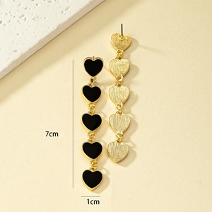 Detail view of gold heart drop earrings showing 7cm length and black enamel finish