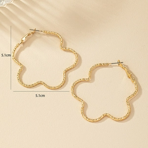 Détail des créoles ondulées dorées de 5,1 cm avec un design de pétale texturé