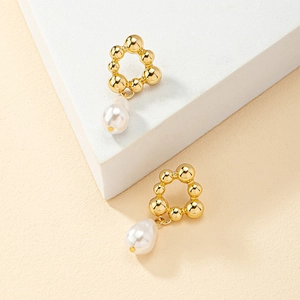 Boucles d'oreilles fleur en perle et anneaux dorés sur support géométrique chic