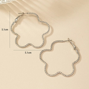 Détail de boucles d'oreilles créoles pétales 5,1cm argentées avec texture tissée et ondulations