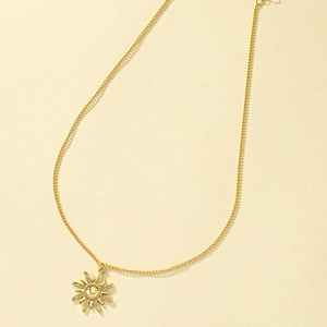 Élégant collier pendentif soleil doré avec motif ondulé minimaliste sur fond mat doux