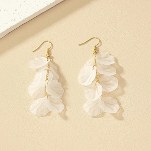 Detail of elegant white resin petal tassel earrings with golden metal chains and fishhooks