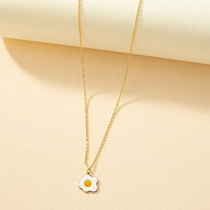 Chic gold necklace with a cute enamel fried egg pendant on a minimalist cream background