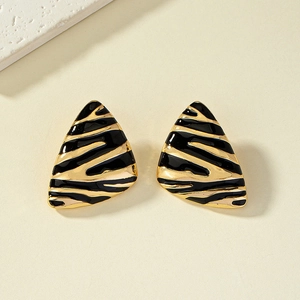 Détail de boucles d'oreilles triangulaires émaillées à motif zèbre doré