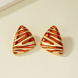Gros plan sur des boucles d'oreilles triangulaires émaillées à rayures orange et or