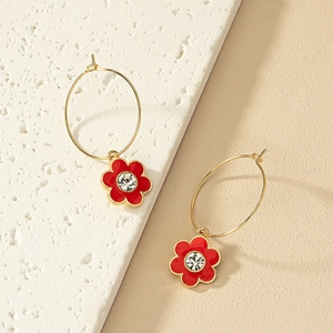 Elegante goldene Creolen mit roten Emaille-Blumenanhängern und funkelnden Strasssteinen