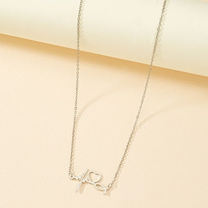 Gros plan d'un collier argenté avec pendentif stéthoscope et ligne de battement de coeur