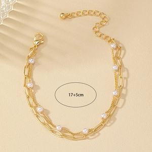 Détail d'un bracelet de perles doré double couche avec chaîne réglable de 17+5cm