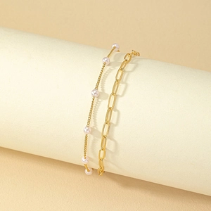 Ensemble de bracelets multicouches dorés avec perles blanches élégantes sur support