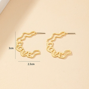 Detail der goldenen LOVE-Ohrringe mit Wellentextur und Maßen von 3 cm mal 2,3 cm