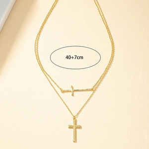 Collier double couche à pendentif croix dorée avec chaîne de 40+7cm sur fond beige