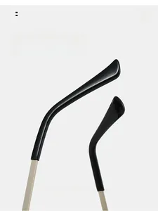 Detail of curved black mirror legs with polished finish and gold metal hinges