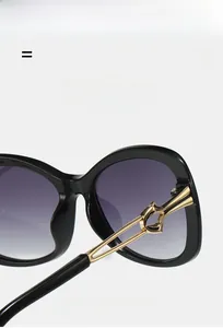 Macro detail of golden hollow metal hinges on large black square fashion sunglasses