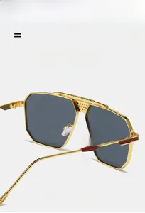 Détail de lunettes pilote en métal avec texture antidérapante et accents rouges aux branches