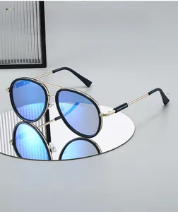 Detail of blue mirrored aviator lenses with gold metal frames reflecting on a glass surface
