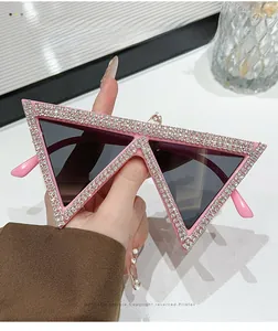 Dettaglio degli occhiali da sole triangolari rosa con decorazioni in strass brillanti