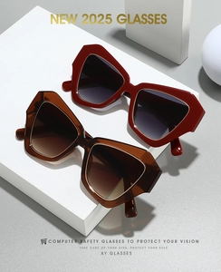 Macro view of burgundy and amber oversized geometric glasses on white blocks