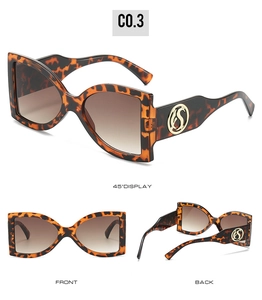 Détail des lunettes de soleil en écaille avec logo doré et verres dégradés marron