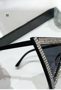 Dettaglio dei bordi con strass su occhiali da sole triangolari oversize alla moda