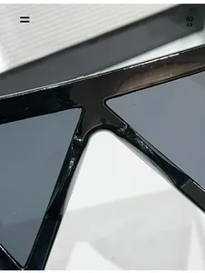 Dettaglio macro dei naselli integrati su occhiali da sole neri oversize alla moda