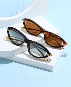 Detail of cat eye sunglasses featuring elegant gold chain knot hinges and gradient lenses