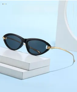 Detail of cat-eye sunglasses with black frame and golden metal knot decorative accents