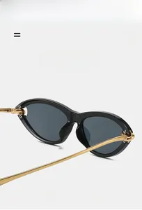 Detail of cat eye sunglasses with black frame and elegant gold metal temples