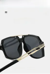 Detail view of vintage square sunglasses with black frame and golden metal temples