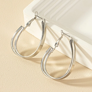 Boucles d'oreilles créoles géométriques argentées polies avec design goutte épuré