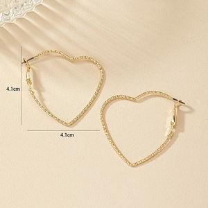 Macro view of 4.1cm gold heart hoop earrings showing intricate woven metal texture