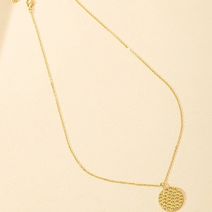 Minimalist gold honeycomb coin pendant necklace with a polished metallic finish