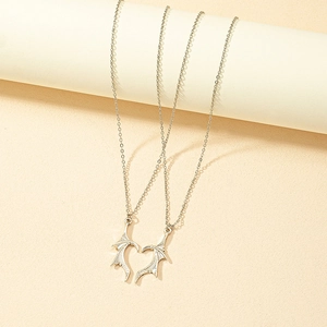 Gothic heart bat wing pendant necklaces in silver finish for couples on a display stand