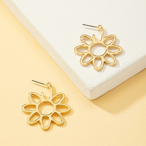 Minimalist hollow flower earrings in gold finish set on white textured stone background